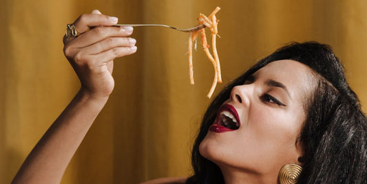 Frau isst Spaghetti mit Gabel