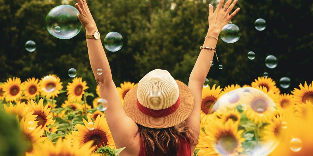 Eine Frau im Sonnenblumenfeld hat Freude, dank genügend Dopamin