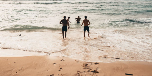 Vier Personen rennen ins Meer