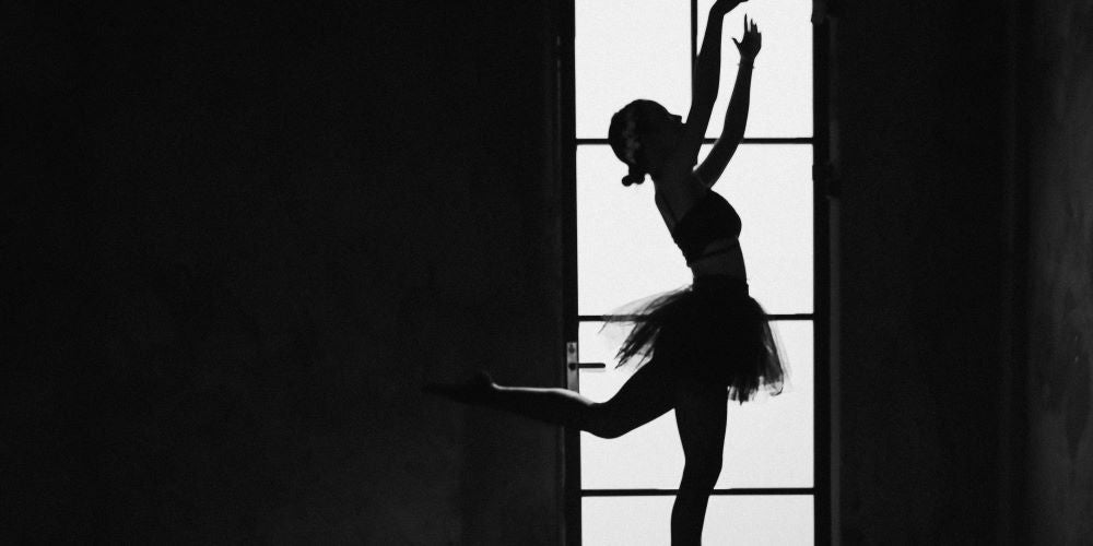 Bild zeigt eine tanzende Ballerina im Gegenlicht