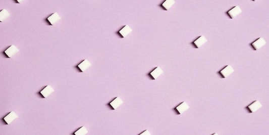 Zuckerwürfel symmetrisch auf rosa Hintergrund platziert