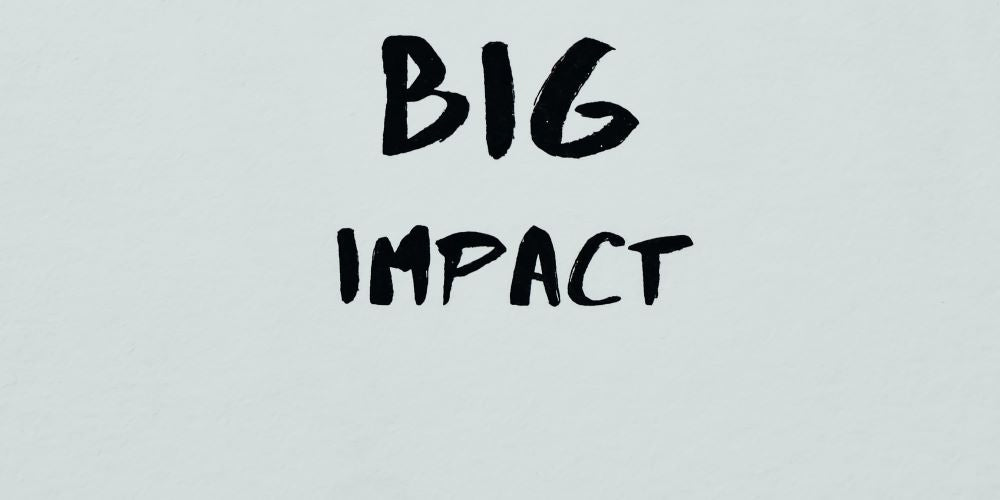"Big Impact" in schwarz von Hand auf weisses Papier geschrieben