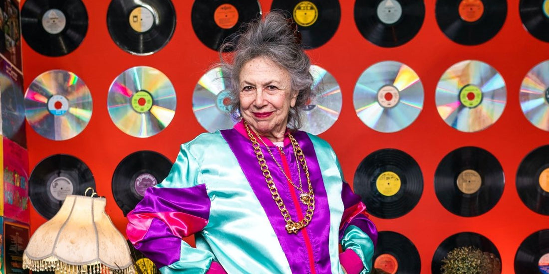 Hippe Oma vor roter Wand voller Schallplatten