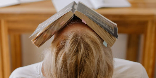 Frau schläft mit Buch auf Kopf