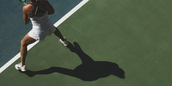 Tennis Spielerin in weissem Kleid von oben.